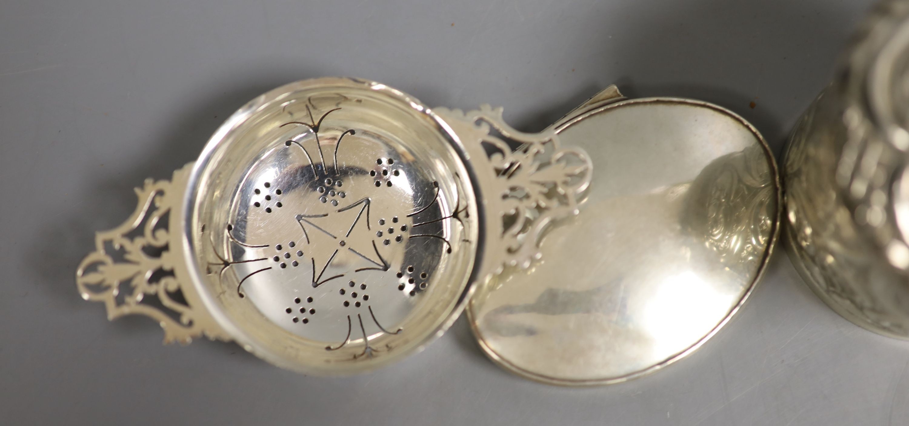 A Georgian silver snuff box of oval form, together with a small tea strainer and three other silver boxes, 10.5oz.